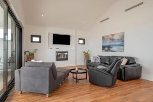 a living room with two couches and a tv at Port Lane Townhouse in Geographe