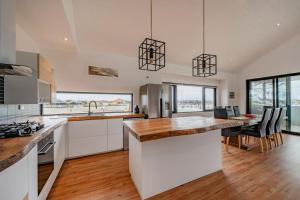 a kitchen with white cabinets and a table with chairs at Port Lane Townhouse in Geographe