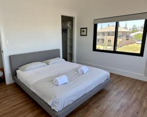 um quarto com uma cama com duas toalhas em Port Lane Townhouse em Geographe
