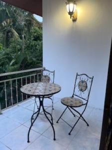 a table and two chairs on a balcony at Kata Sea Blue Villa in Kata Beach