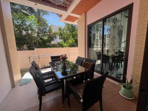 a balcony with a table and chairs on a patio at Kata Sea Blue Villa in Kata Beach
