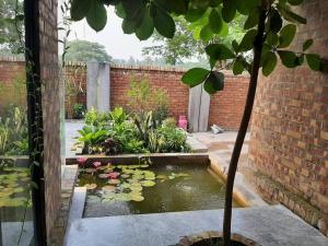 un jardín con un estanque koi en una pared de ladrillo en YJ Homes, 