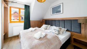 a bedroom with two beds with white pillows at Wonder Home - Domki górskie z kominkami, bezpłatnym parkingiem i placem zabaw na terenie kompleksu in Karpacz