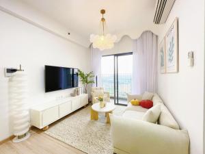 uma sala de estar com um sofá e uma televisão em MRT Apartment In Masteri Thao Dien em Ho Chi Minh