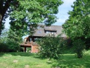 a large house with trees in front of it at Ferienwohnungen Seeblick in Unterkirnach