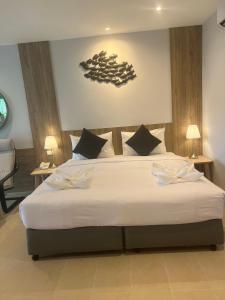 a bedroom with a large bed with white sheets at Evergreen Resort in Chaweng
