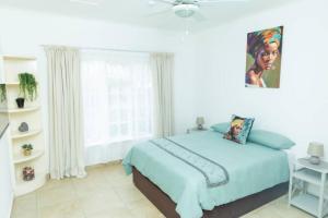 1 dormitorio con cama y ventana grande en The Cottages @ Ezulwini, en Lobamba