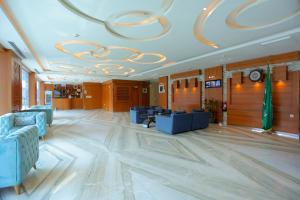 a large lobby with blue chairs and a large ceiling at هوستا الملقا in Riyadh