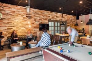 a group of people playing pool in a restaurant at Wellness in the Woods - 4p TinyHouse met privé sauna & hottub in Diessen
