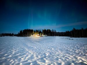 a house in the middle of a snow covered field at Lomatalo Honkamäki in Kuhmalahti