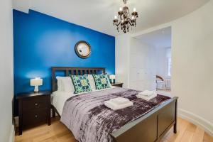 a bedroom with a blue accent wall and a bed at Welcome London St Martin's in London