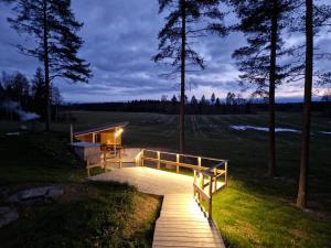 une passerelle en bois menant à un champ la nuit dans l'établissement Lomatalo Honkamäki, 