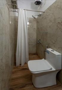 een badkamer met een wit toilet en een douche bij Elite Inn Cholai Lake View Resort in Taingapatam