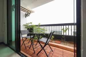 a patio with a table and chairs on a balcony at Cozy 2 bedroom w pool for 6 - Seri Kembangan in Seri Kembangan