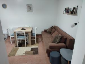 ein Wohnzimmer mit einem Sofa und einem Tisch in der Unterkunft Apartman Gradina Zlatibor in Zlatibor