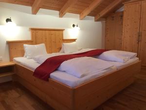 Cama grande en habitación con paredes de madera en Apartment Hinkerhof, en Schladming