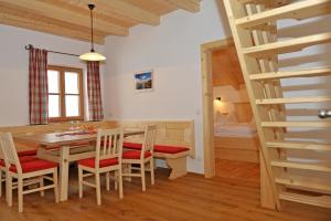 a dining room with a table and chairs and a bedroom at Apartment Hinkerhof in Schladming