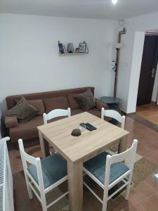 einen Holztisch und Stühle im Wohnzimmer in der Unterkunft Apartman Gradina Zlatibor in Zlatibor