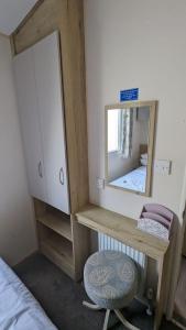 a dressing table with a mirror and a stool at Superb 8 Berth Caravan At Steeple Bay Holiday Park, Essex Ref 36039f in Southminster