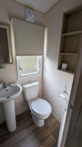 een kleine badkamer met een toilet en een wastafel bij Superb 8 Berth Caravan At Steeple Bay Holiday Park, Essex Ref 36039f in Southminster