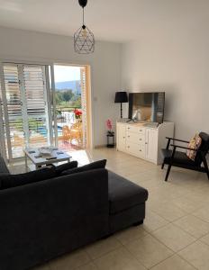 ein Wohnzimmer mit einem schwarzen Sofa und einem TV in der Unterkunft Mountain View Apartment - Polis in Polis Chrysochous