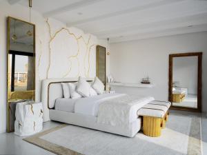 a white bedroom with a large bed and a mirror at Ramlah Resort Qatar in Mesaieed