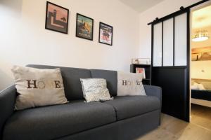 - un canapé gris avec des oreillers dans le salon dans l'établissement expat renting - L’Evasion - Saint Michel - Métro, à Toulouse