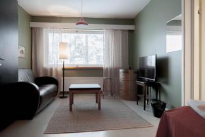 a living room with a couch and a table and a television at Kulkuri hostellit Hämeenlinna in Hämeenlinna