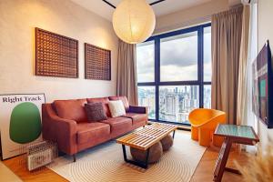 ein Wohnzimmer mit einem Sofa und einem großen Fenster in der Unterkunft Urban Suites, Classic Collection by Stellar ALV in Jelutong