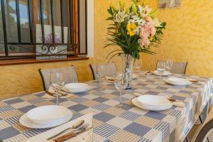 une table avec des assiettes et un vase de fleurs dans l'établissement CASA RURAL C PUENTE DEL SEGURA, à Elche de la Sierra
