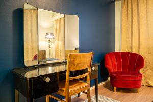 a dressing room with a desk and a red chair at Kulkuri hostellit Hämeenlinna in Hämeenlinna