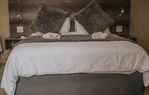 1 dormitorio con 1 cama grande y toallas. en Casa Leitao Lodge, en Phalaborwa