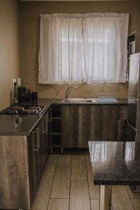 cocina con fregadero y ventana en Casa Leitao Lodge, en Phalaborwa
