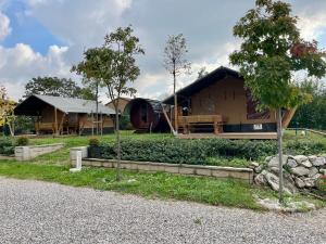 a large wooden house with trees and a building at Borgo Terra village in Fagagna