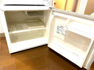 an empty refrigerator with its door open in a kitchen at Tokyo Stay Waseda in Tokyo
