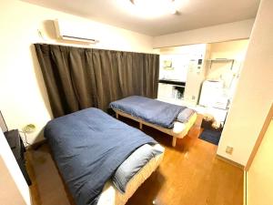 a bedroom with two beds and a window with curtains at Tokyo Stay Waseda in Tokyo