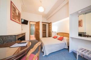 ein Hotelzimmer mit einem Bett und einem Schreibtisch in der Unterkunft Hôtel du Centre in Metz