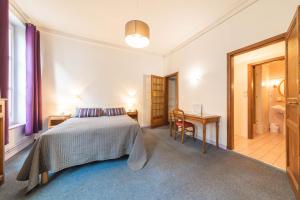 a bedroom with a bed and a table and a desk at Hôtel du Centre in Metz