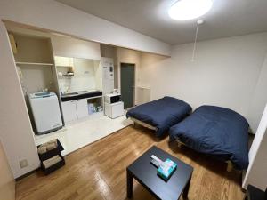 a small room with two beds and a table at Tokyo Stay Waseda in Tokyo