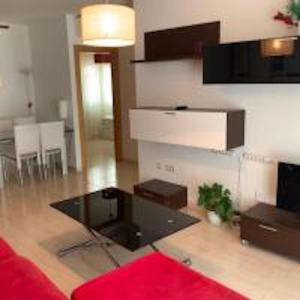 - un salon avec un canapé rouge et une table dans l'établissement Apartments Holidays2Malaga City Center, à Malaga