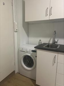 a kitchen with a washing machine and a sink at Gamle Oslo Apartments in Oslo