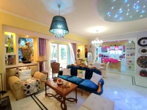 sala de estar con sofá azul y mesa en Primavera Holiday Home, en Vrachati