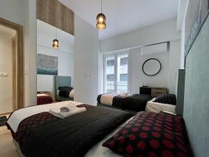 雅典的住宿－Stunning 2 BR Near Acropolis，一间卧室配有两张床和镜子