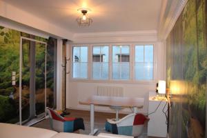 sala de estar con mesa y ventana en Résidence Loanie & Soins en Châlus