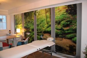 een kamer met uitzicht op een bosmuurschildering bij Résidence Loanie & Soins in Châlus