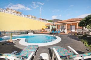 una piscina con tumbonas y una casa en Eveas, en Candelaria