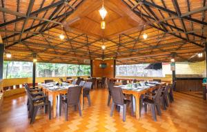 a dining room with wooden tables and chairs at The Kanila Resort in Karjat