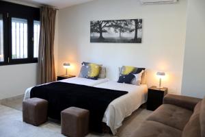 um quarto com 2 camas e um sofá em Villa lujo Costa del Sol con piscina-jacuzzi em Torremolinos