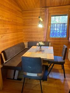 a dining room with a table and chairs and a window at Ferienhaus Nr 10, Typ A, Feriendorf Jägerpark, Bayerischer Wald in Viechtach
