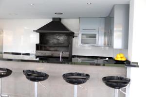 uma cozinha com bancos de bar pretos e um fogão em Villa lujo Costa del Sol con piscina-jacuzzi em Torremolinos